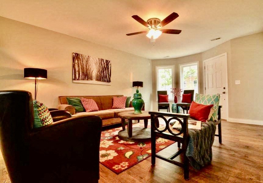 a living room filled with furniture and a ceiling fan