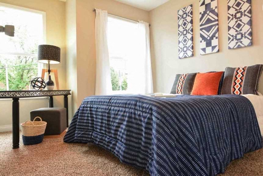 a bedroom with a bed and two windows