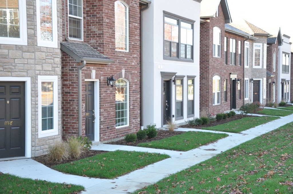a sidewalk in front of a row of town houses