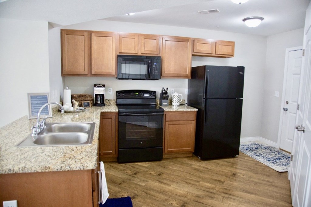 a kitchen with black appliances and wooden cabinets