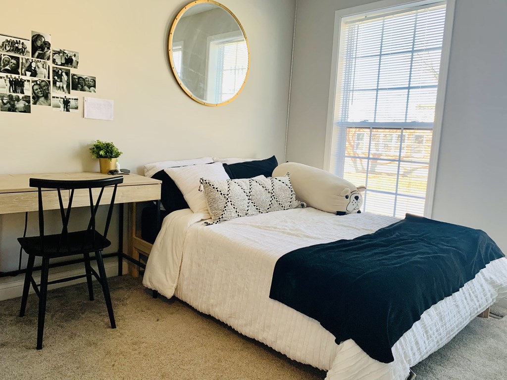 a bedroom with a bed and a desk with a mirror