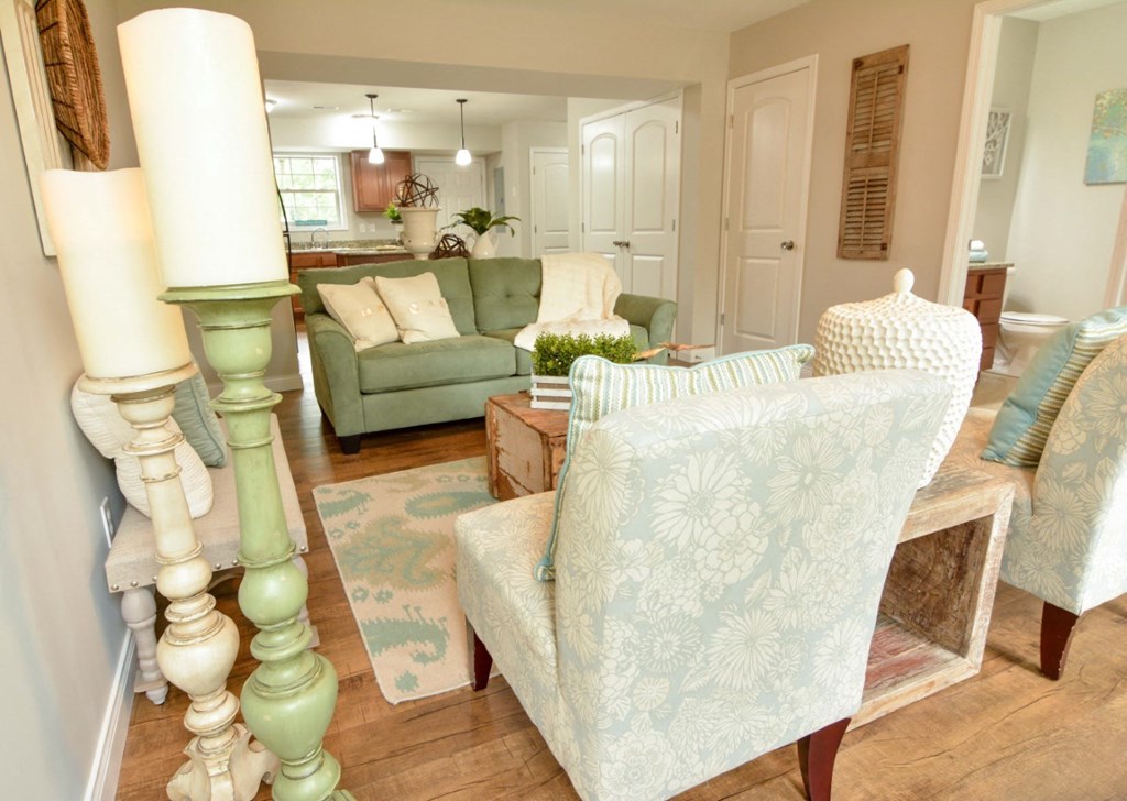 a living room with white chairs and a green couch