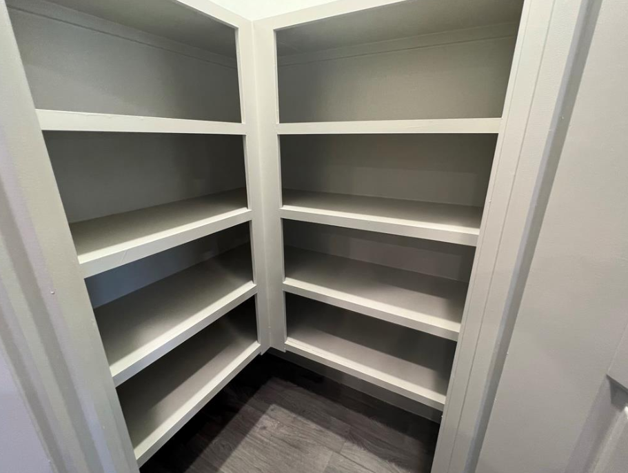 Empty white shelves in a pantry.