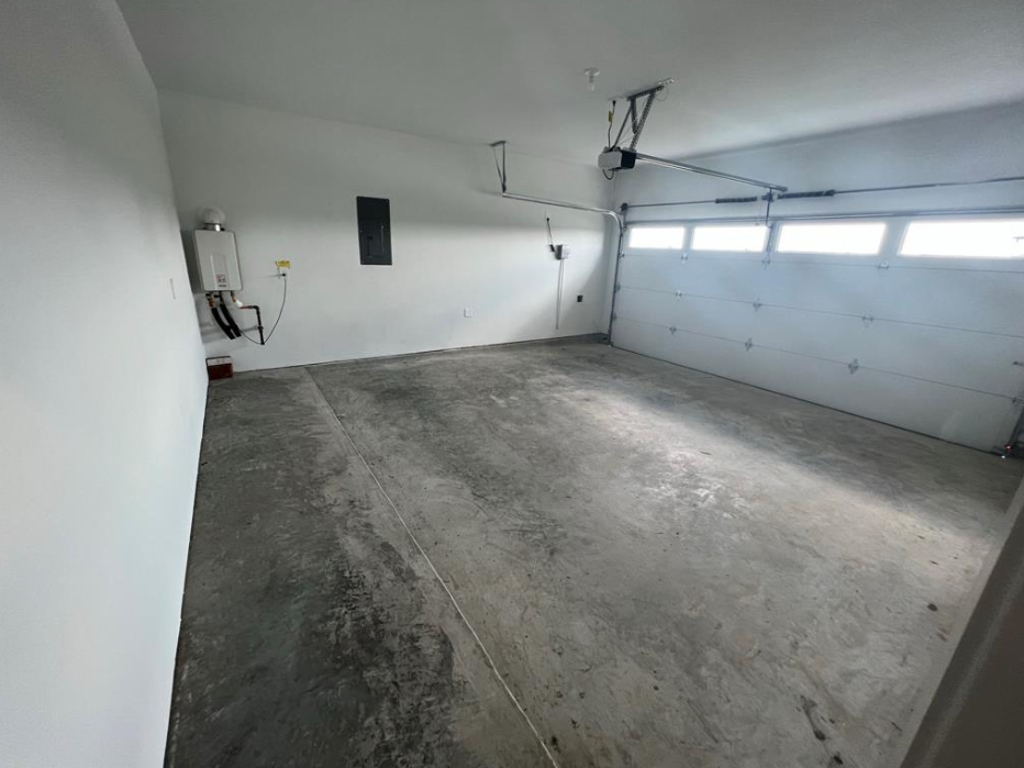 A large empty garage with concrete floors and white walls.