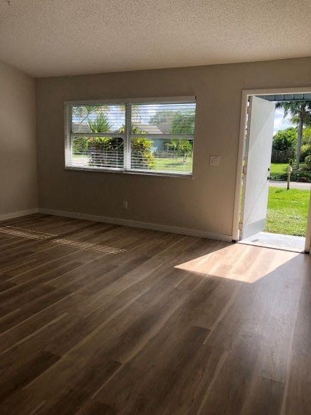 A room with wooden flooring and a window with blinds.