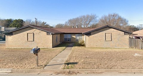 a brick house with a parking meter in front of it