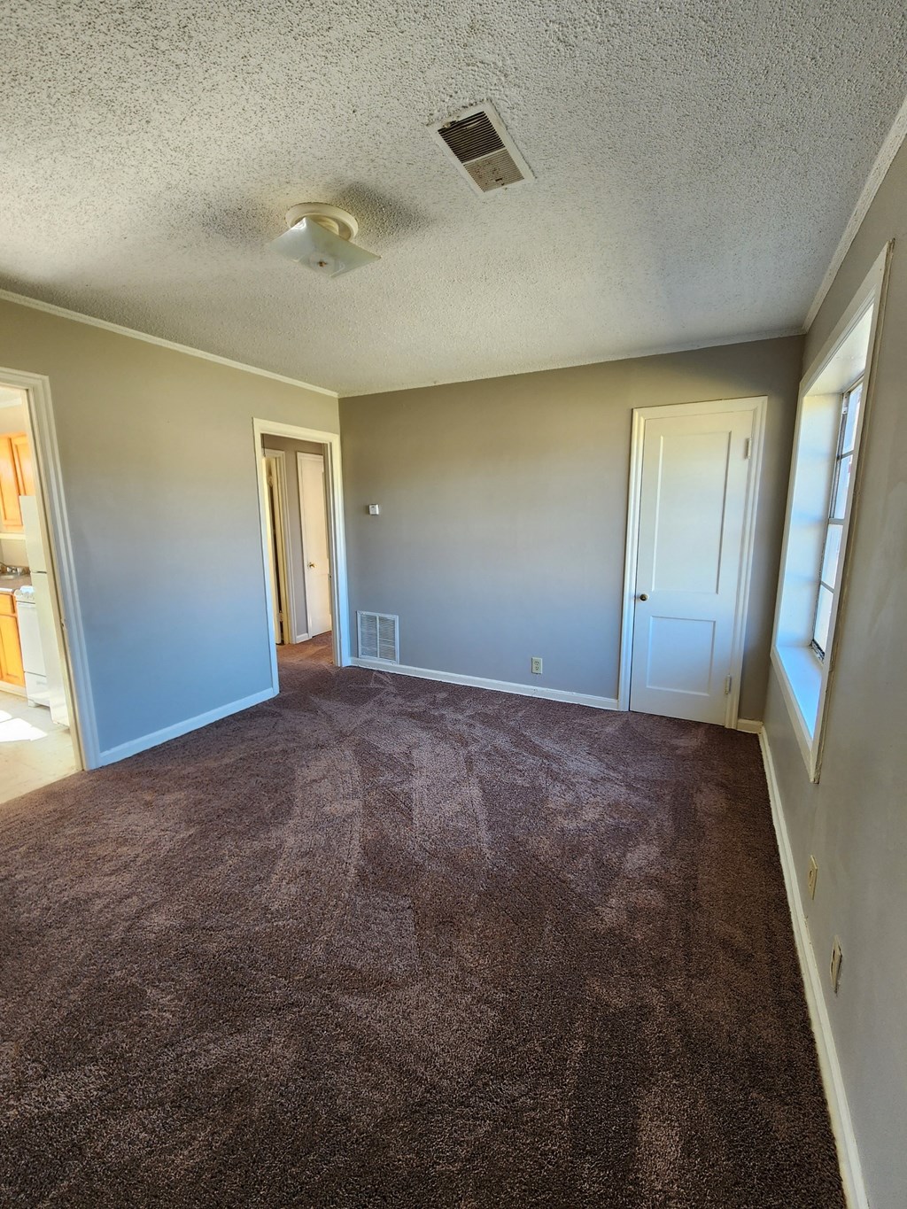 an empty living room with carpet and blue walls