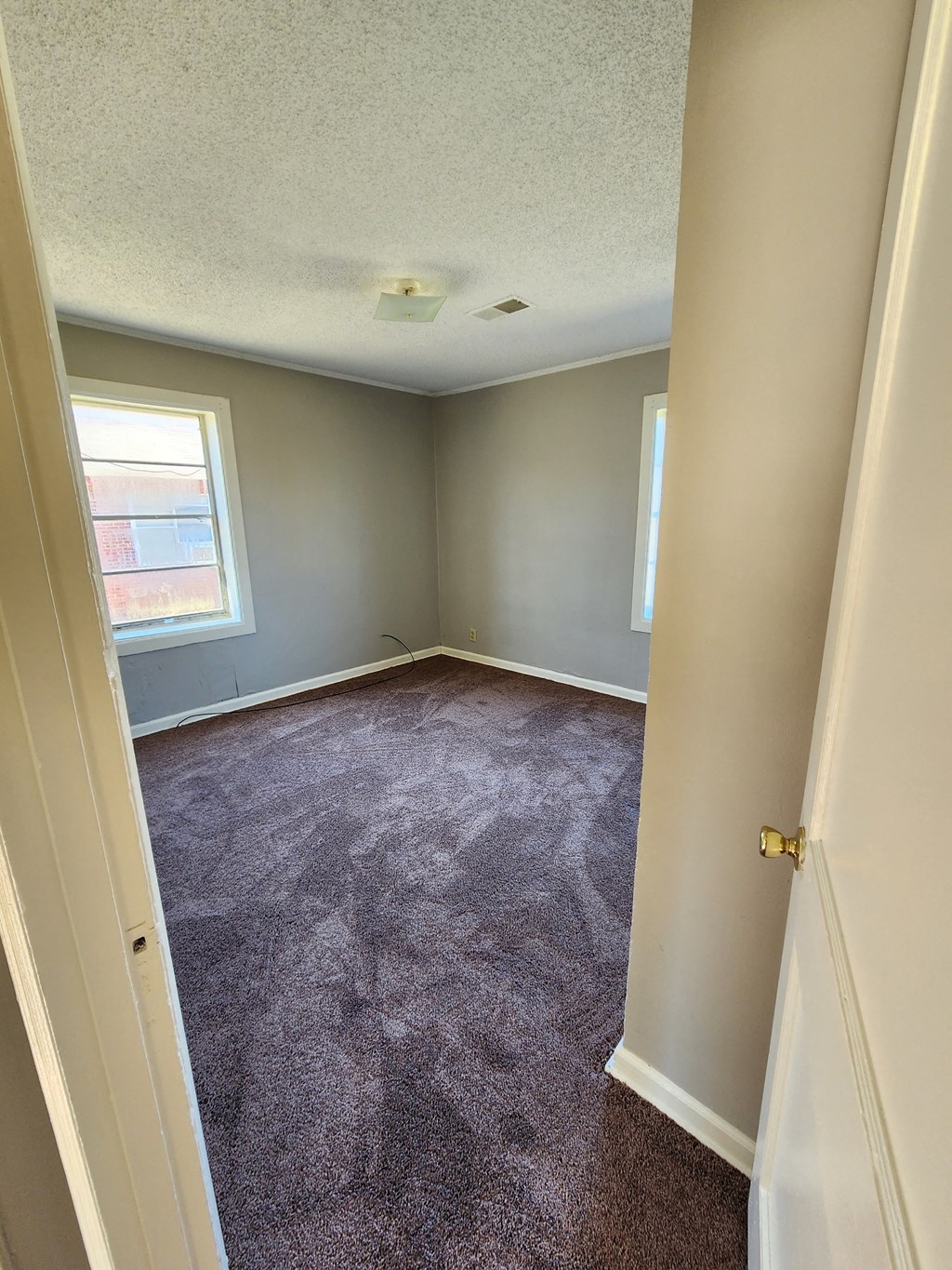 an empty room with carpet and a window