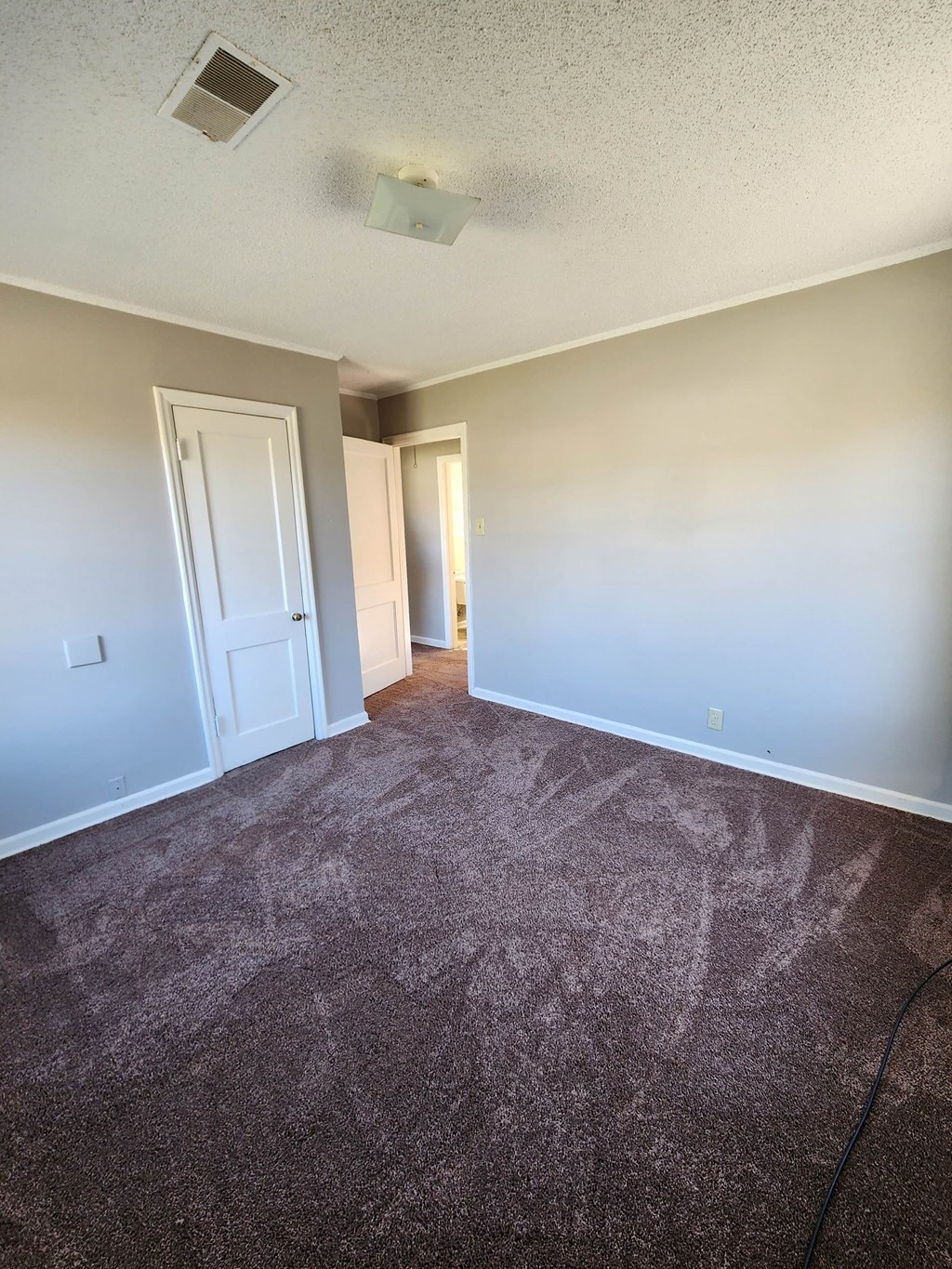 an empty living room with carpet and blue walls
