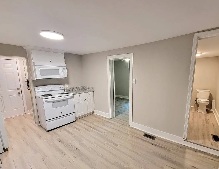 an empty kitchen with a stove and a microwave