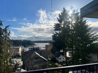 A view from a balcony overlooking a residential area with houses and trees.