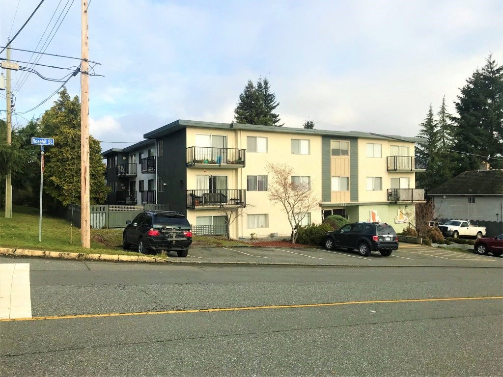 an apartment building with cars parked in front of it