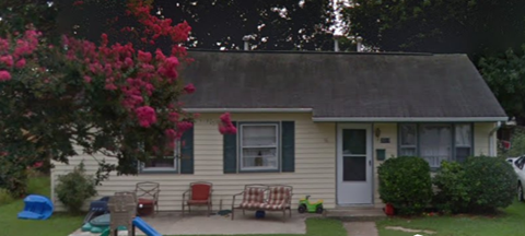 a house with a yard and a rocking chair in front of it