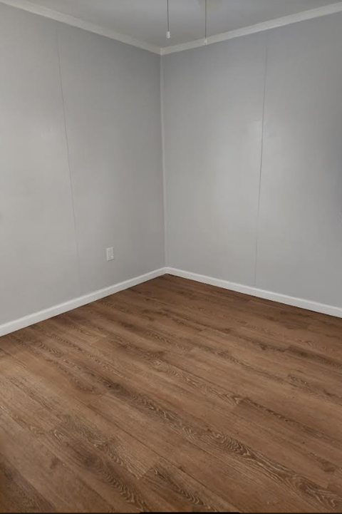 an empty room with wooden floors and white walls