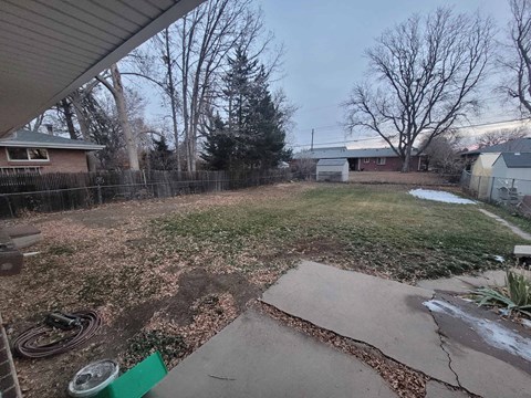 the backyard of a house with a yard and a fence