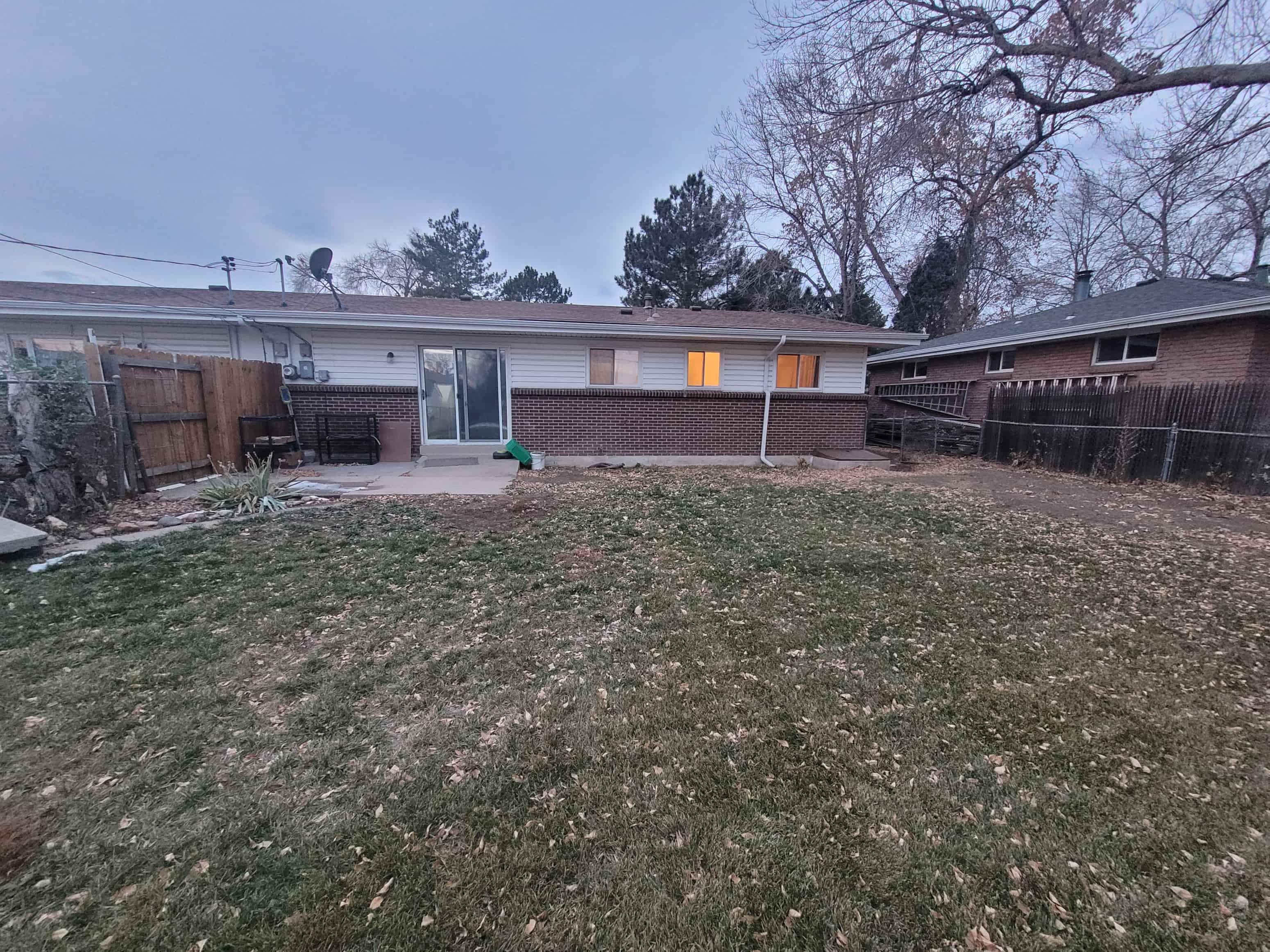 a house with a yard and a fence in front of it