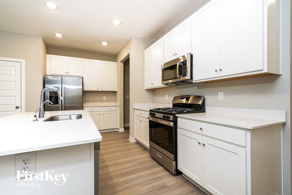 A kitchen with white cabinets and appliances.