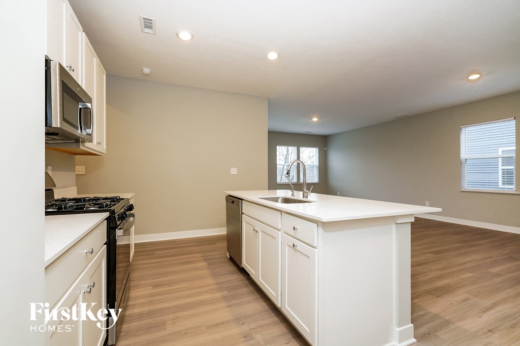 A kitchen with white cabinets and a black stove top oven.