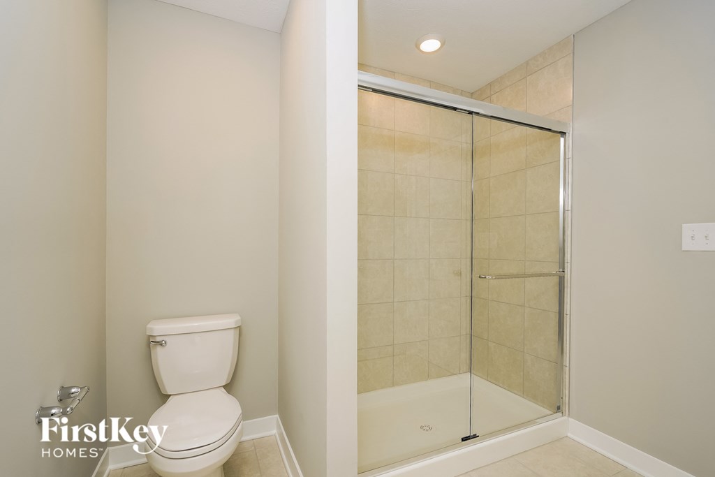 A white toilet in a bathroom with a walk-in shower.