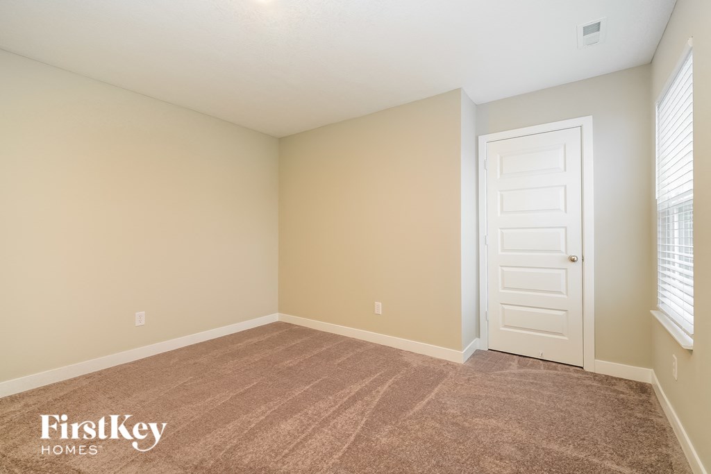A room with a carpeted floor and a white door.