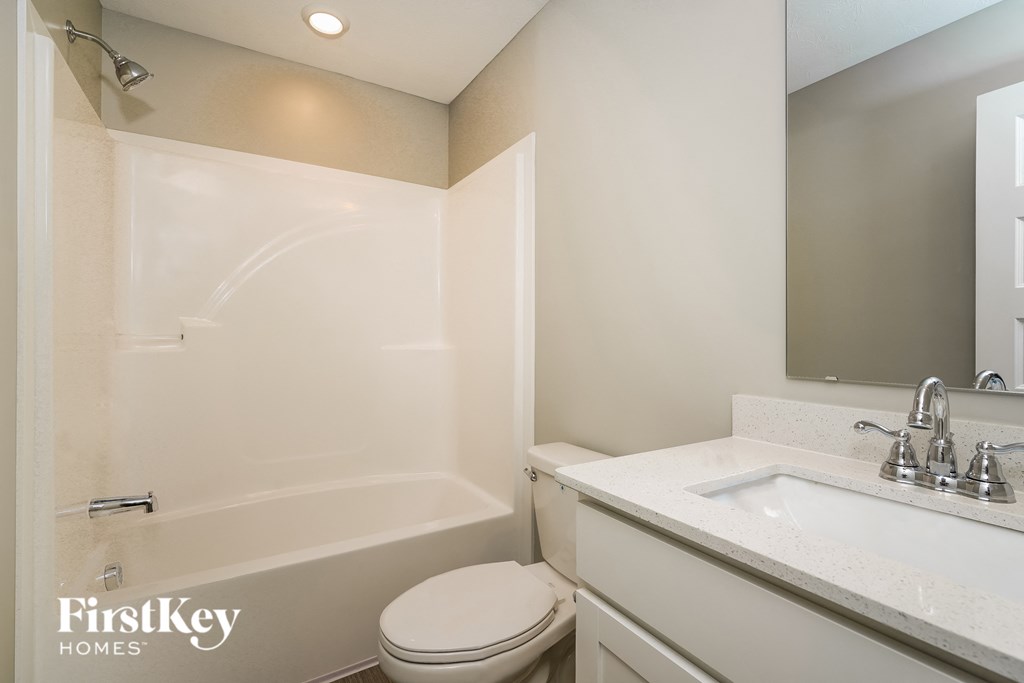 A white toilet sits next to a white sink in a bathroom.