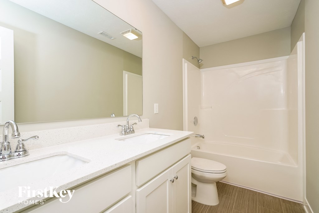 A bathroom with a white sink and toilet.