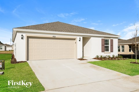 a beige house with a garage door and a driveway