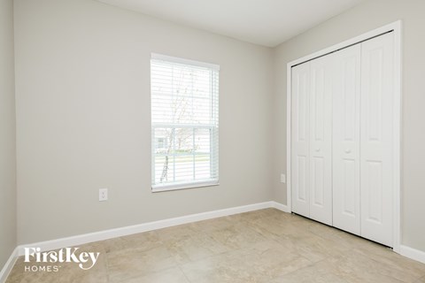 a bedroom with a door and a window and a tiled floor
