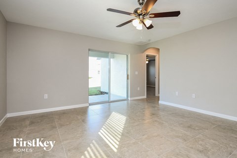 the spacious living room with tile flooring and a ceiling fan