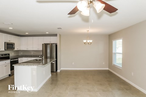 A kitchen with a stainless steel refrigerator and a ceiling fan.
