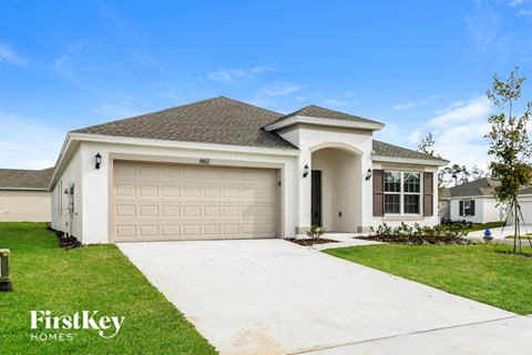 a white house with a garage door and a driveway