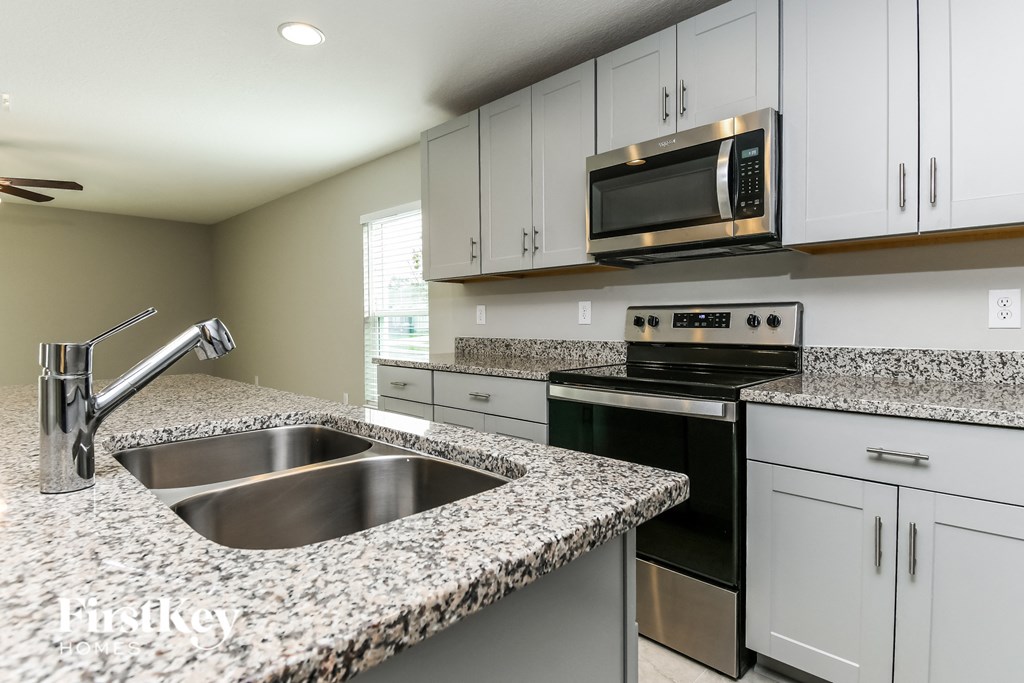 a kitchen with granite counter tops and white cabinets