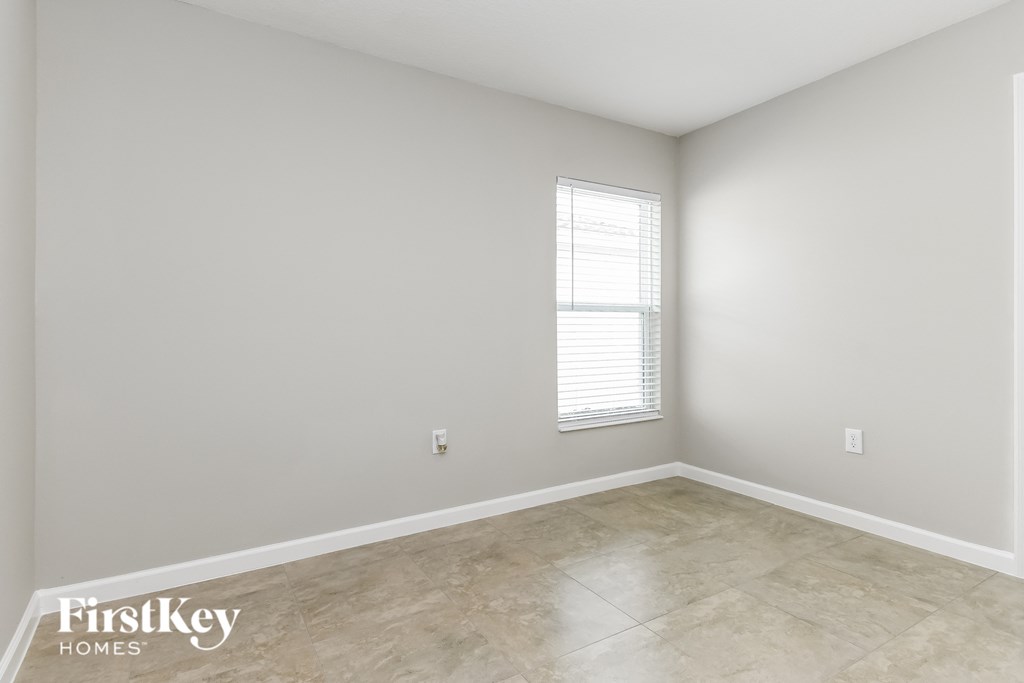 the living room of a new home with white and gray walls and a window