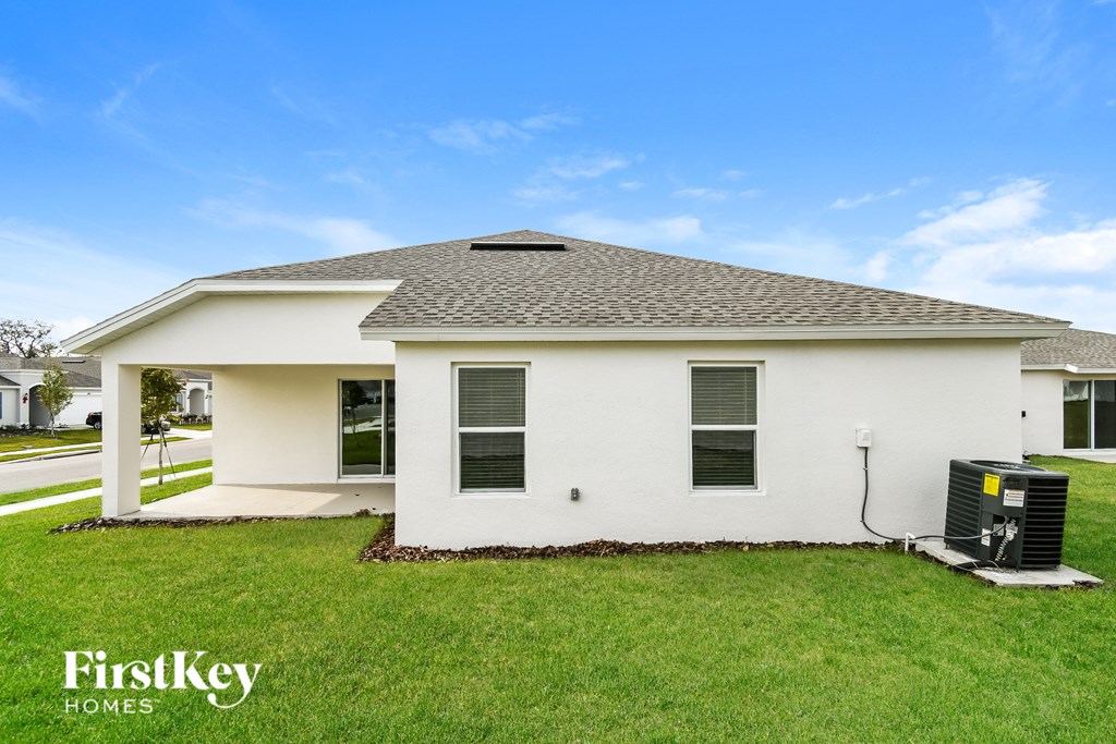 a white house with a black roof on a green lawn