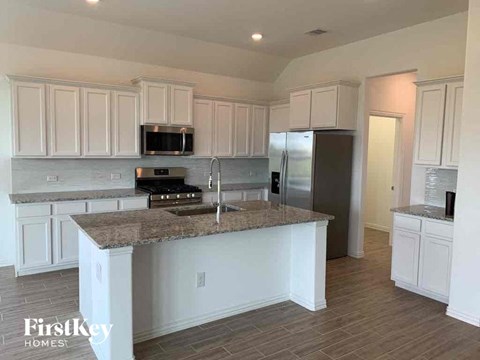 A kitchen with a granite countertop and stainless steel appliances.