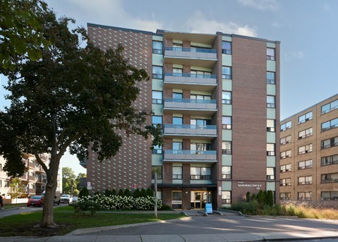 A tall apartment building with a brick facade and balconies.
