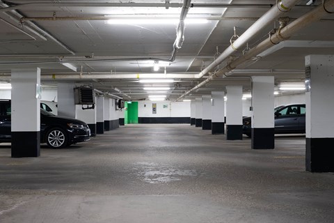 A parking garage with a black car parked on the left side.