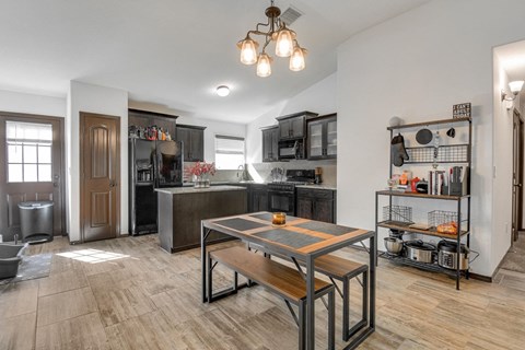 a kitchen and dining room with a wooden table and a counter top