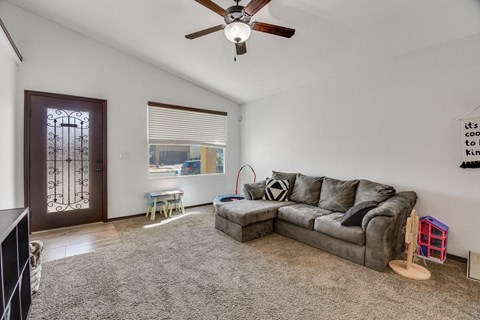 a living room with a couch and a ceiling fan