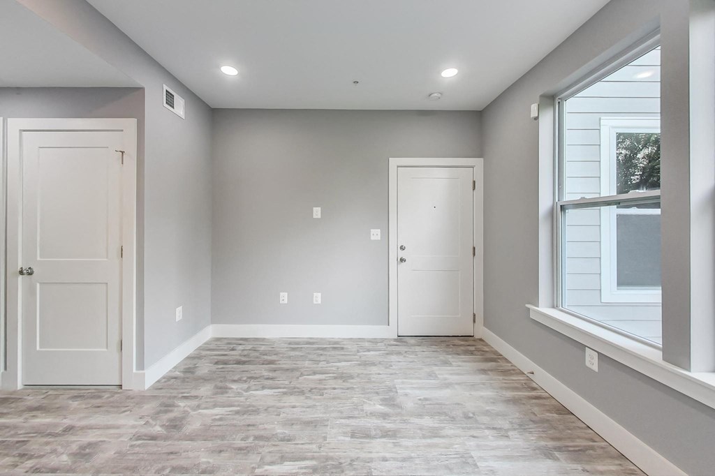 an empty room with a window and a door