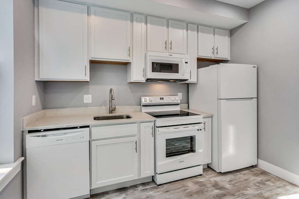 a white kitchen with white appliances and white cabinets