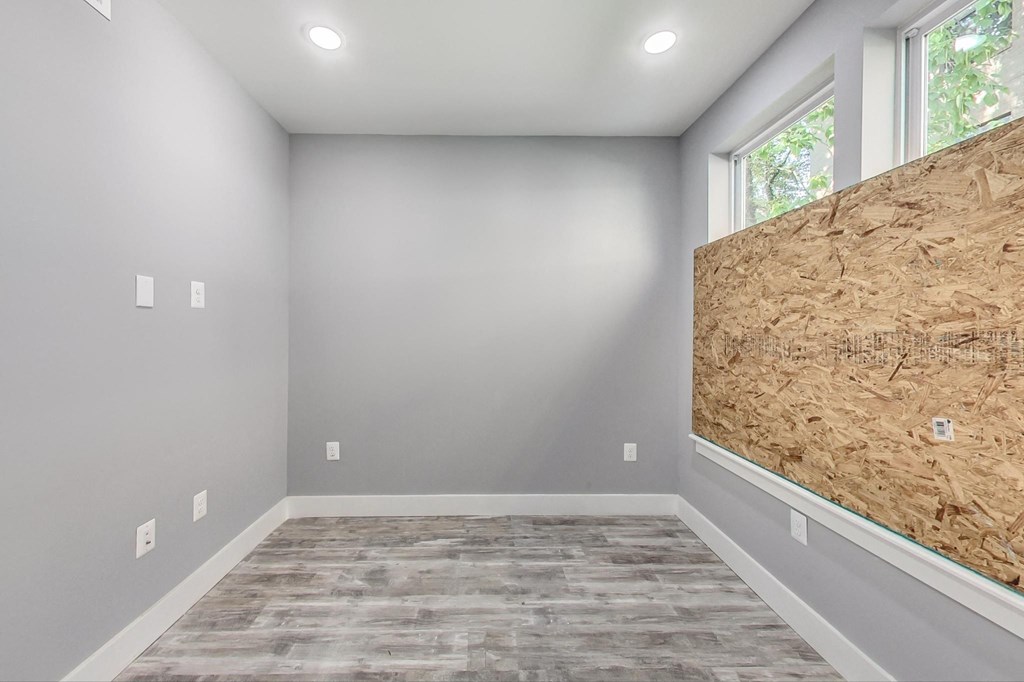a room with a large window and a wall with plywood on the wall