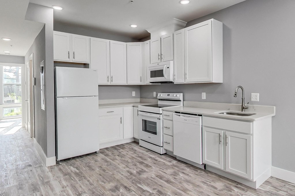 a kitchen with white cabinets and a sink and a refrigerator