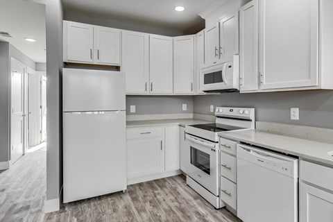 a white kitchen with white cabinets and white appliances