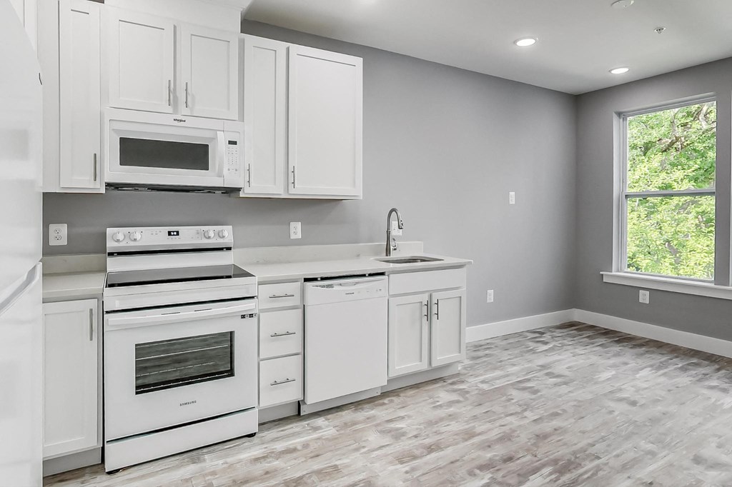 the kitchen of a new home with white cabinets and appliances