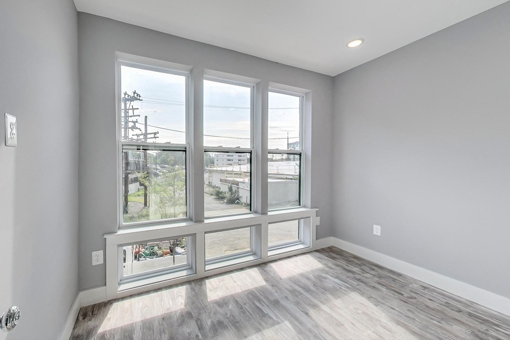 the living room of a new home with large windows and wood floors