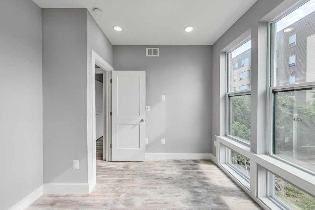 an empty room with large windows and a door