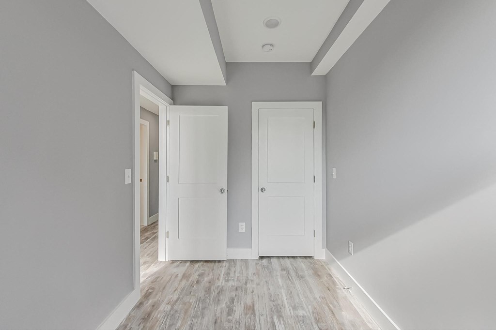 a freshly renovated room with white doors and grey walls