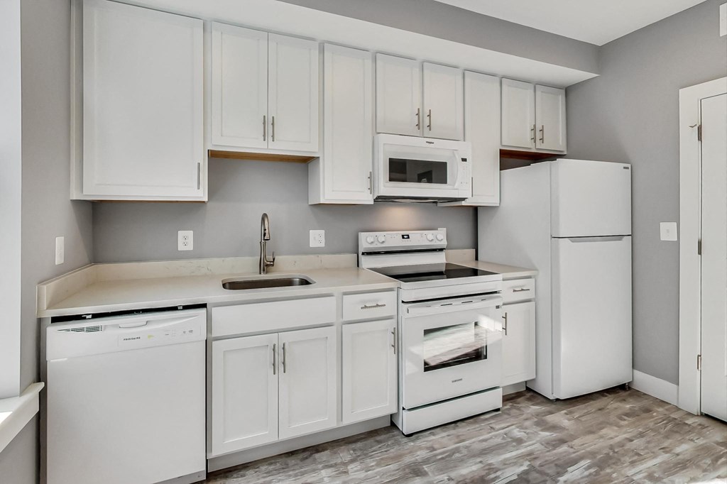 a white kitchen with white appliances and white cabinets