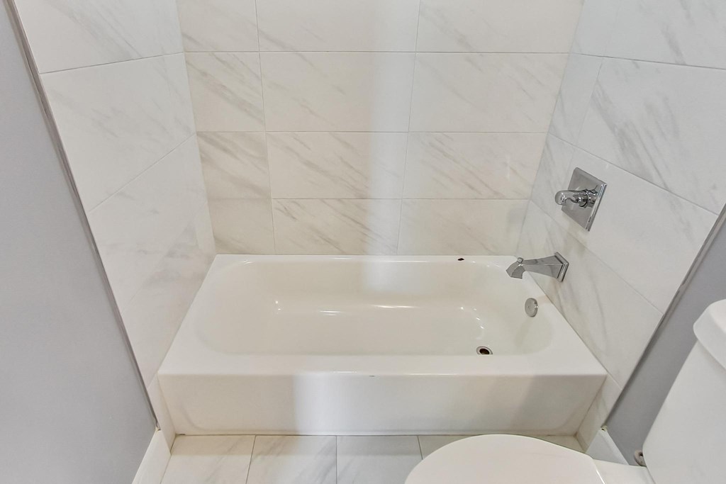 a white bathroom with a tub and a toilet